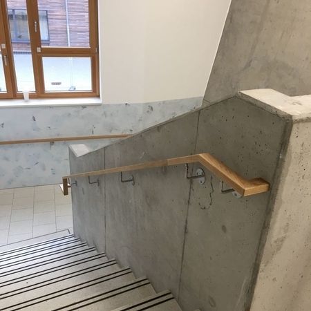 Eine Treppe mit einem Handlauf und einem Fenster im Hintergrund.